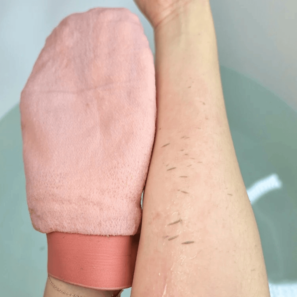Guante Exfoliante GLIMS en uso: piel muerta saliendo del brazo